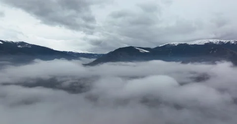 Flight from clouds layer to reveil a mounta peak in a great cold morning. Stock Footage 174390029