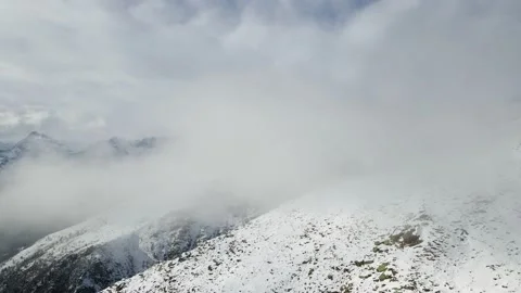 Flight into the clouds in mountain environment with snow in winter. Alps 4k Stock Footage 148031206
