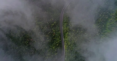 Flight in the clouds. A view of the earth through the clouds. A winding mountain Stock Footage 77660080