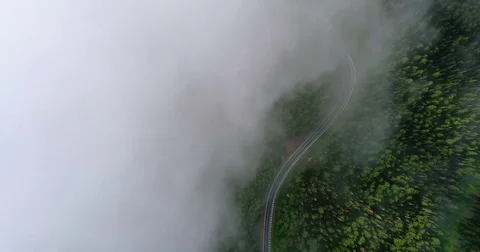Flight in the clouds. A view of the earth through the clouds. A winding mountain Stock Footage 77660167