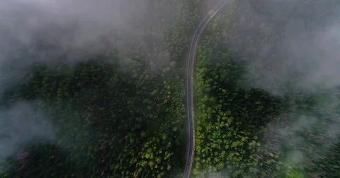 Flight in the clouds. A view of the earth through the clouds. A winding mountain Stock Footage 77660198