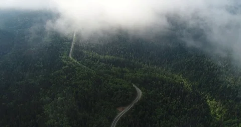 Flight in the clouds. A view of the earth through the clouds. A winding mountain Stock Footage 77660298