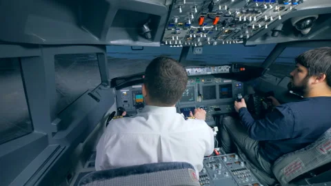 Flight coach is demonstrating to another man how to manage flight simulator 動画素材 93655000
