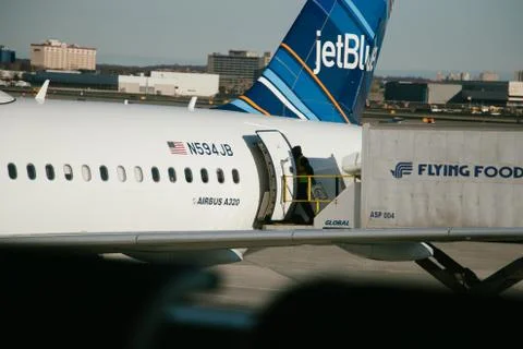 A flight controller boards a Jetblue airbus A320 from a terminal Stock Photos