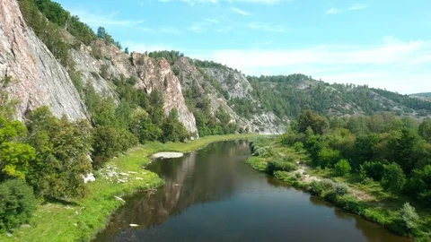 Flight of the copter over the river at the foot of a mountainous rocky ridge. 스톡 동영상 114874744