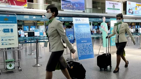 Flight crew wearing mask, walking in a Vietnamese airport Video stock 142183694