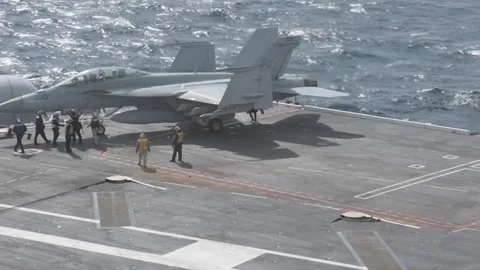 Flight deck crew operating around an F/A-18 Hornet during Flight Operations Video stock 254152836
