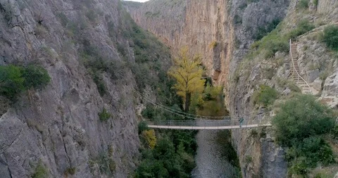Flight descending from drone inside rock gorge and retired hiker bottom Stock Footage 124386918