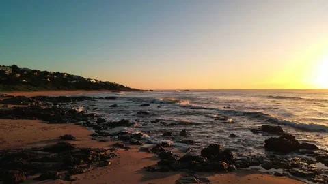 Flight down beach over rocks into sun Vídeos de archivo 238832917