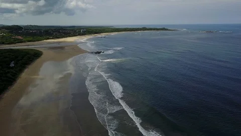 Flight down Playa Grande shore towards Tamarindo estuary Stock Footage 91010563