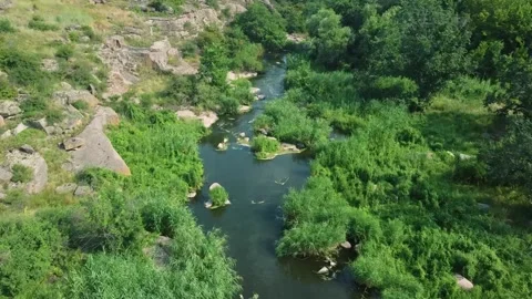 Flight of the drone at medium speed over the river’s water stream through the Stock Footage 134075856