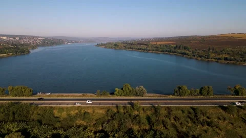 The flight of the drone over a highway with moving cars and a lake in the Stock Footage 163336229