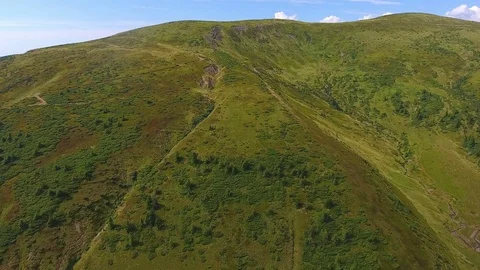 Flight of a drone over a mountain covered with green grass Stock Footage 83981500