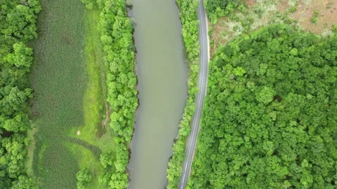 Flight with drone over a road around a river 動画素材 131744467