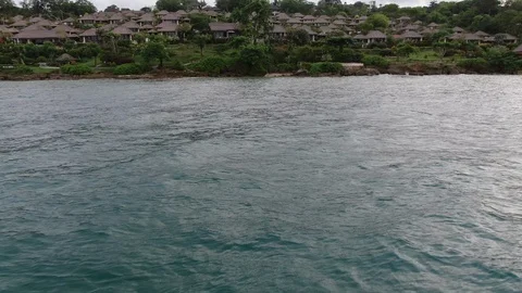 Flight of a drone over a tropical cottage village on the seashore. Stock Footage 124822854