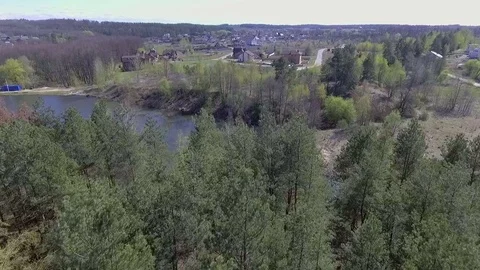 Flight of a drone over a village in a forest near a lake Stock Footage 74453302