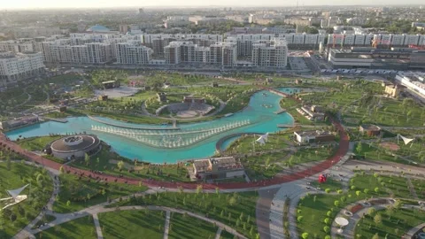 The flight of the drone on a sunny day over the park. A beautiful fountain in Stock Footage 247620680