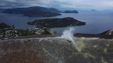 Flight to the edge of the crater of a volcano, over the smoke of a fumarole Stock Footage 121293459