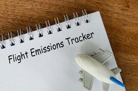 Flight Emissions tracker text on white notepad with small airplane backgrou.. Foto stock
