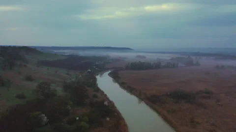 Flight in the evening over a forest clearing and a reservoir Stock Footage 153044675
