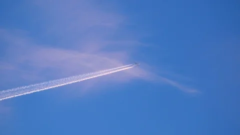 A flight flies heaven high through the frame leaving turbulent wake in the sky Stock Footage 124687438