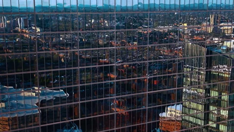 Flight at the glossy mirror facade of the skyscraper reflecting the cityscape. Stock Footage 339749993