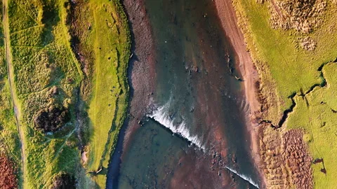 Flight high above the shallow river with rapids. View on the hilly banks covered Stock Footage 327671487