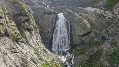Flight to a high-altitude waterfall. A large wide stream flows down from a flat Stock Footage 269297058