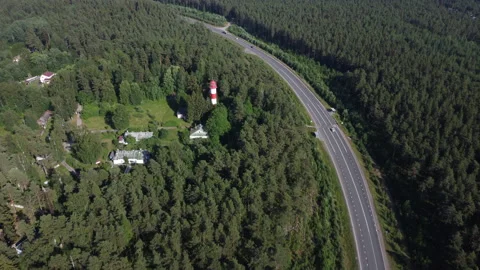 Flight to the lighthouse over the road and forest Stockbeeldmateriaal 160480180