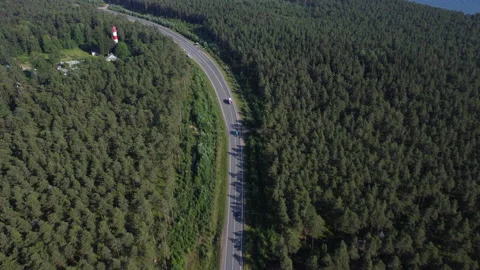 Flight to the lighthouse over the road and forest Stock Footage 160480258