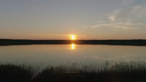 Flight low over lake at sunset. Drone flies above water surface. Stock Footage 133999828