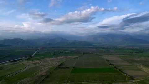 Flight to the mountain range in the valley, rural fields, aerial view Stock Footage 274450356