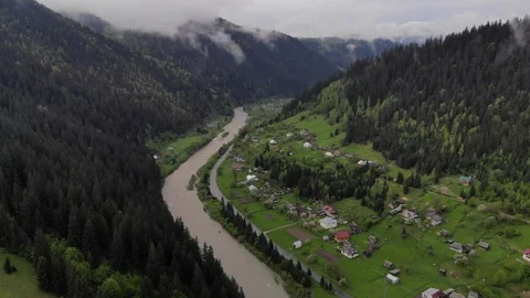 Flight mountain village with forests, fields and river in sunrise soft fog. Video stock 108254112