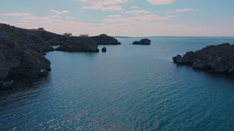 Flight near large rocks on which cormorants bask Stock Footage 126682152