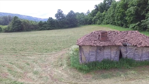 Flight next to Old abandoned cottage next to the forest in the meadow 스톡 동영상 112759670