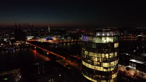 Flight at night over Cologne showing the Rhine and a skyscraper in front of it Video stock 234612947