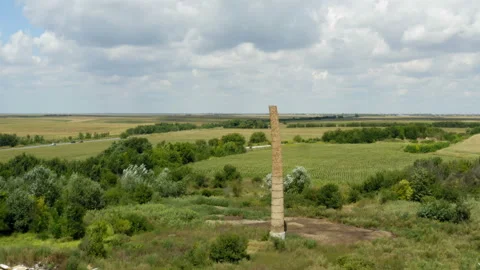 Flight by an old chimney surrounded by wheat fields Stock Footage 137719290
