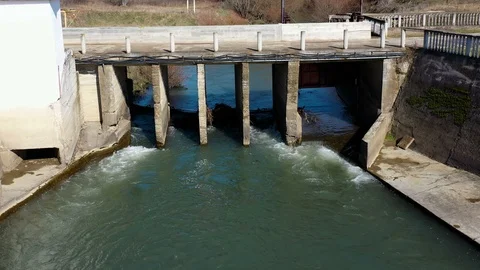 Flight over the abandoned dams on the river and a part of the broken bridge Stockbeeldmateriaal 125290354