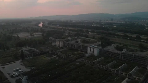 Flight over abandoned hospital with river and city in backround Stock Footage