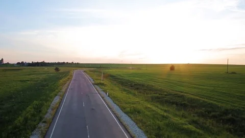 Flight over asphalt road between green fields Stock Footage 72646691