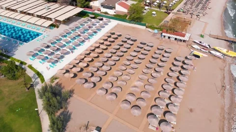 Flight over the beach with umbrellas towards the pool in a luxury hotel Stock Footage 195195576