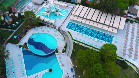 Flight over the beach with umbrellas towards the pool in a luxury hotel Stock Footage 195195628