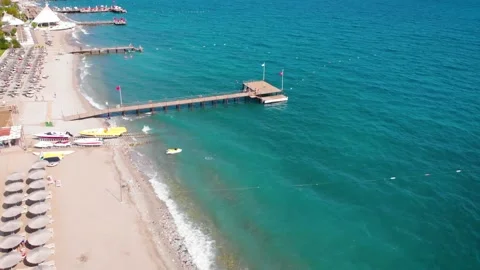 Flight over the beach with umbrellas towards the pool in a luxury hotel Stock Footage 195196355