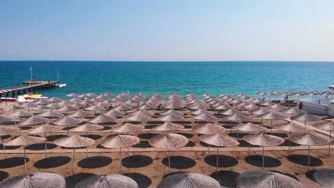 Flight over the beach with umbrellas towards the pool in a luxury hotel Stock Footage 195196966