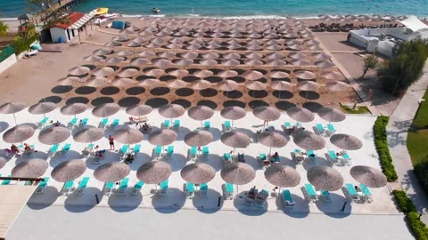 Flight over the beach with umbrellas towards the pool in a luxury hotel Stock Footage 195197142