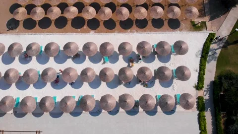 Flight over the beach with umbrellas towards the pool in a luxury hotel Stock Footage 195197305