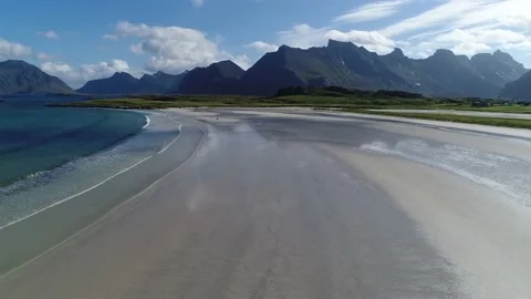 Flight over a beautiful coastal beach  at the foot of magnificent mountains Stock Footage 136847367