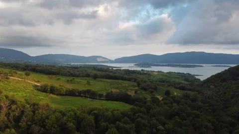 Flight over beautiful forest and lake surrounded by mountains. Fly towards the Stock Footage 263864970
