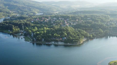 Flight over a beautiful mountain surrounded by a thick forest and a rocky coast Video stock 136317734