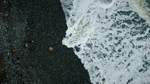 Flight over the black pebble beach at the foot of the extinct volcano Karadag. N Video stock 150568903